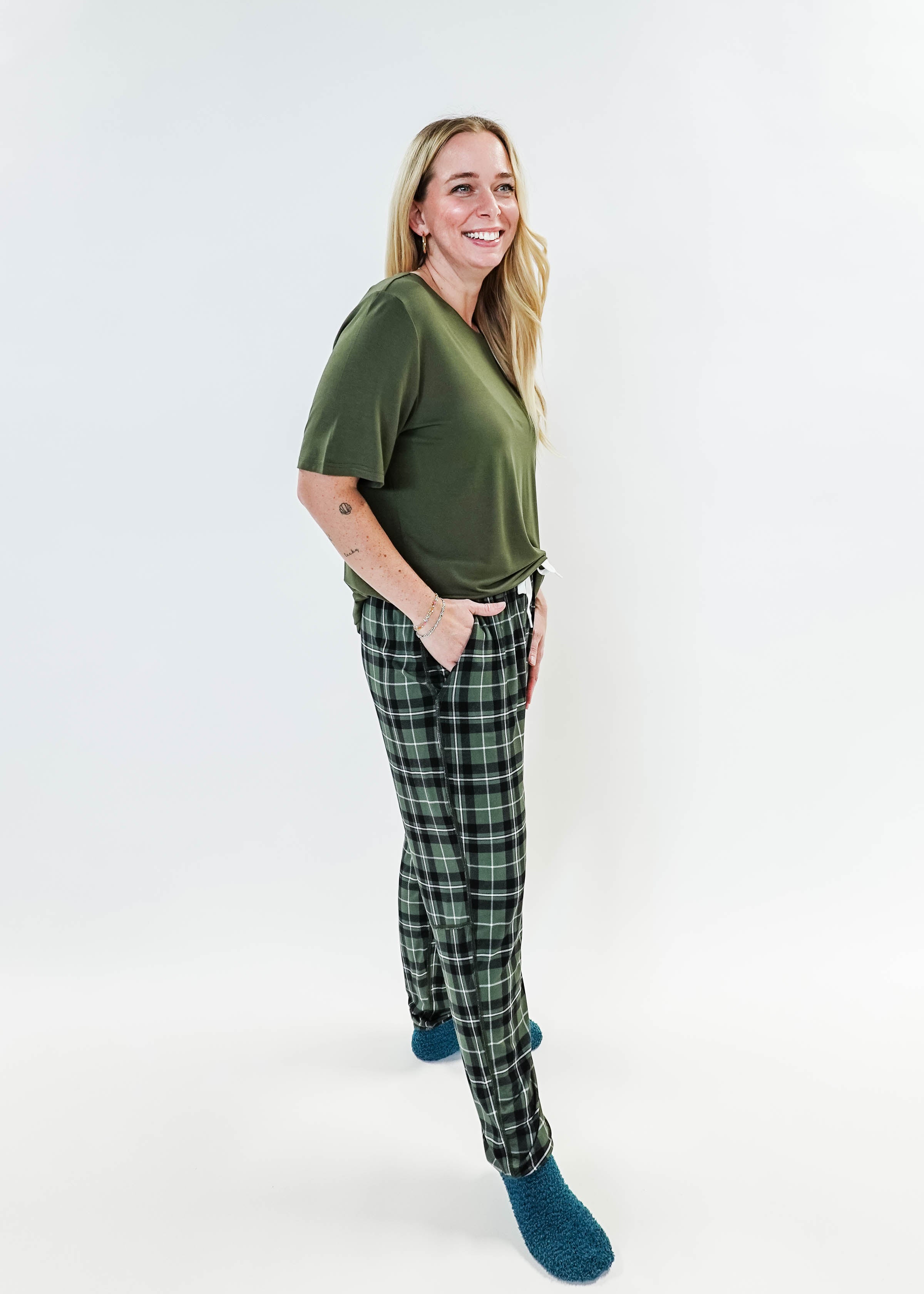 Woman in green top wearing Green Plaid Unisex Bamboo Jogger by Bob's Sleepwear Co. for ultimate comfort.