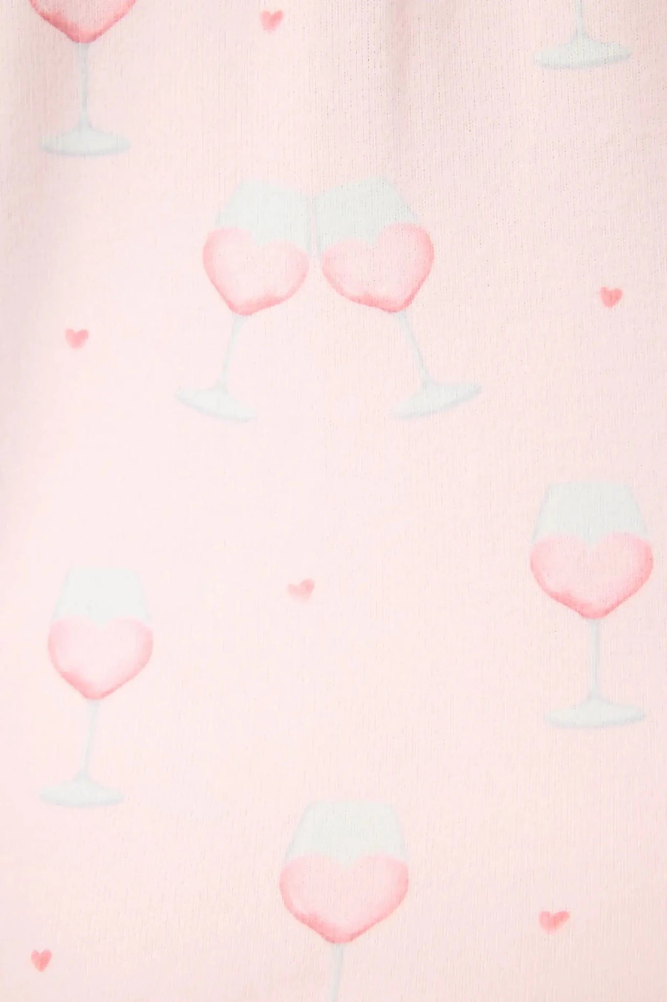 Happy Hour Wine Glass Print 3-Piece PJ Set | PJ Salvage women's wine glass print pj set in pink - button up long sleeve top, straight leg pants, and matching eye mask close up of the pink wine print, the "wine" looks like a heart and there are small hearts around the glass. 