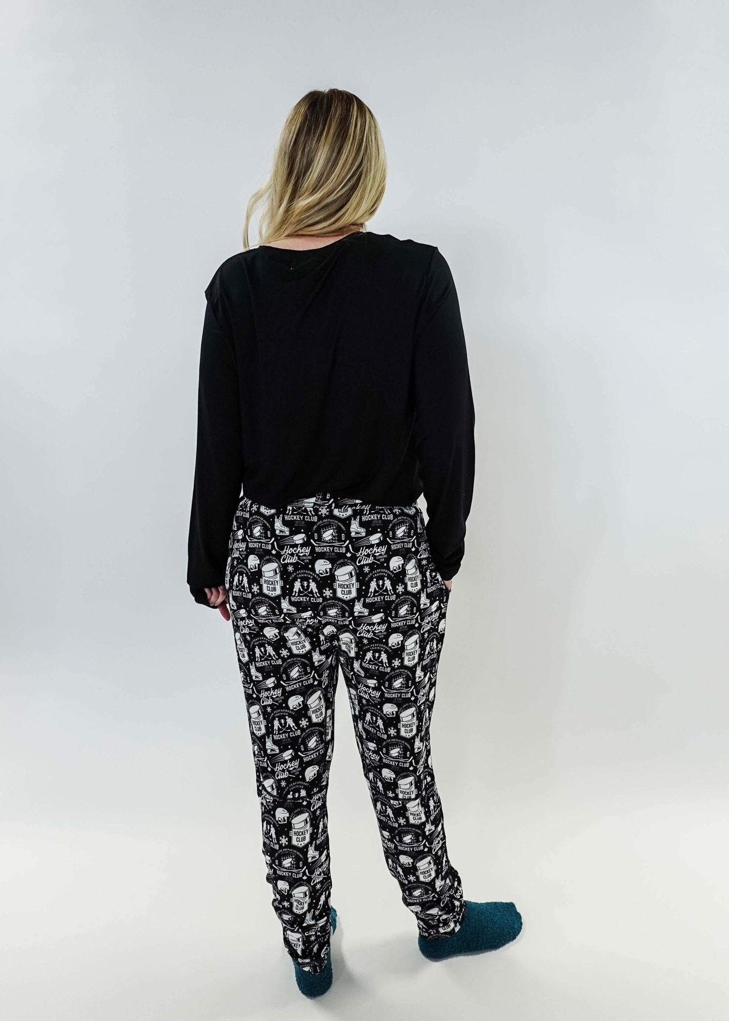 He Scores Hockey Print Unisex Bamboo Jogger worn by a person showing the back view with black top and patterned joggers.