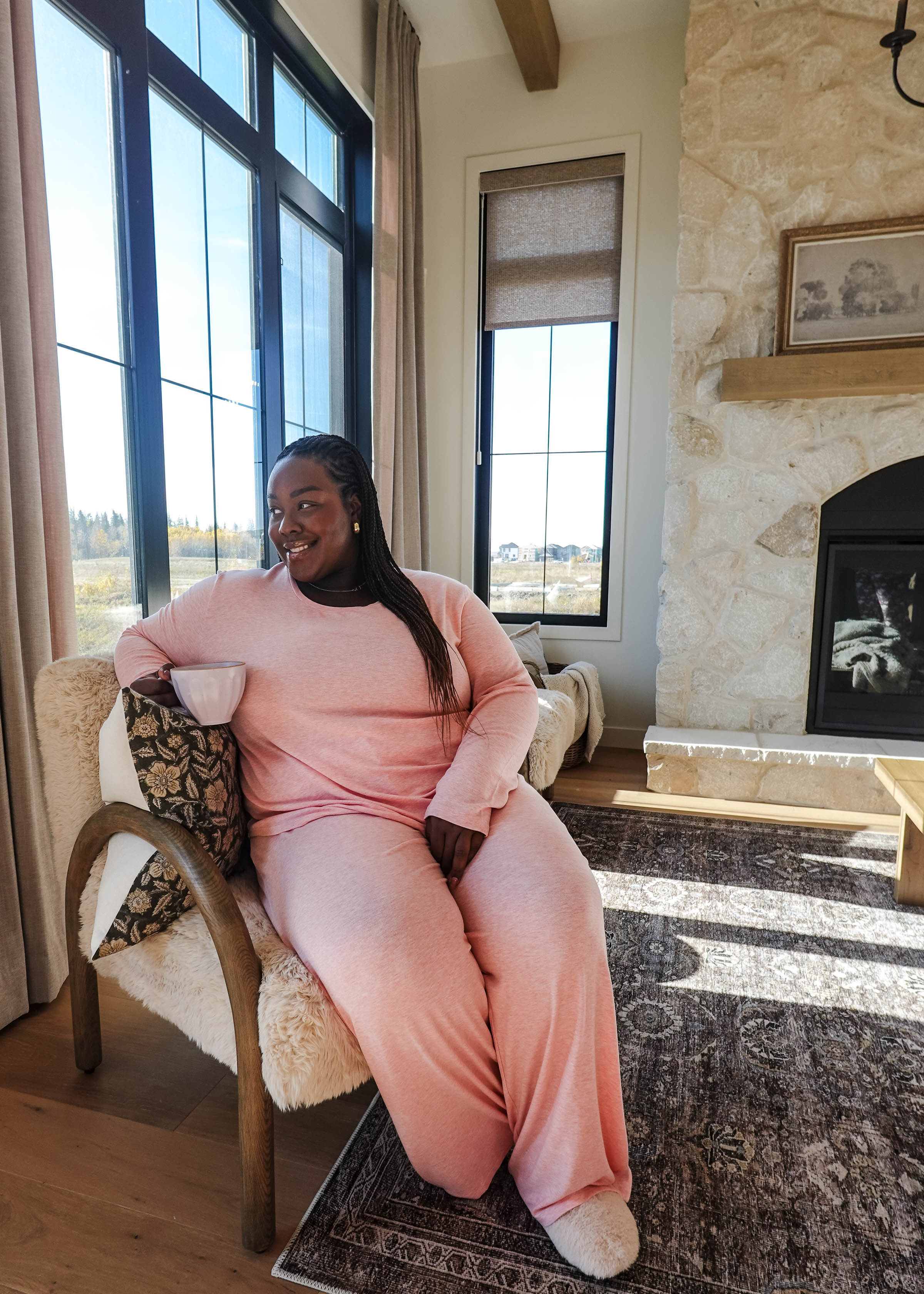 Heather Pink TopStraight Pant Lounge Set worn by a woman sitting in a cozy living room, enjoying a drink.
