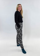 Female model wearing He Scores Hockey Print Unisex Bamboo Jogger with a black long-sleeve top and blue socks.