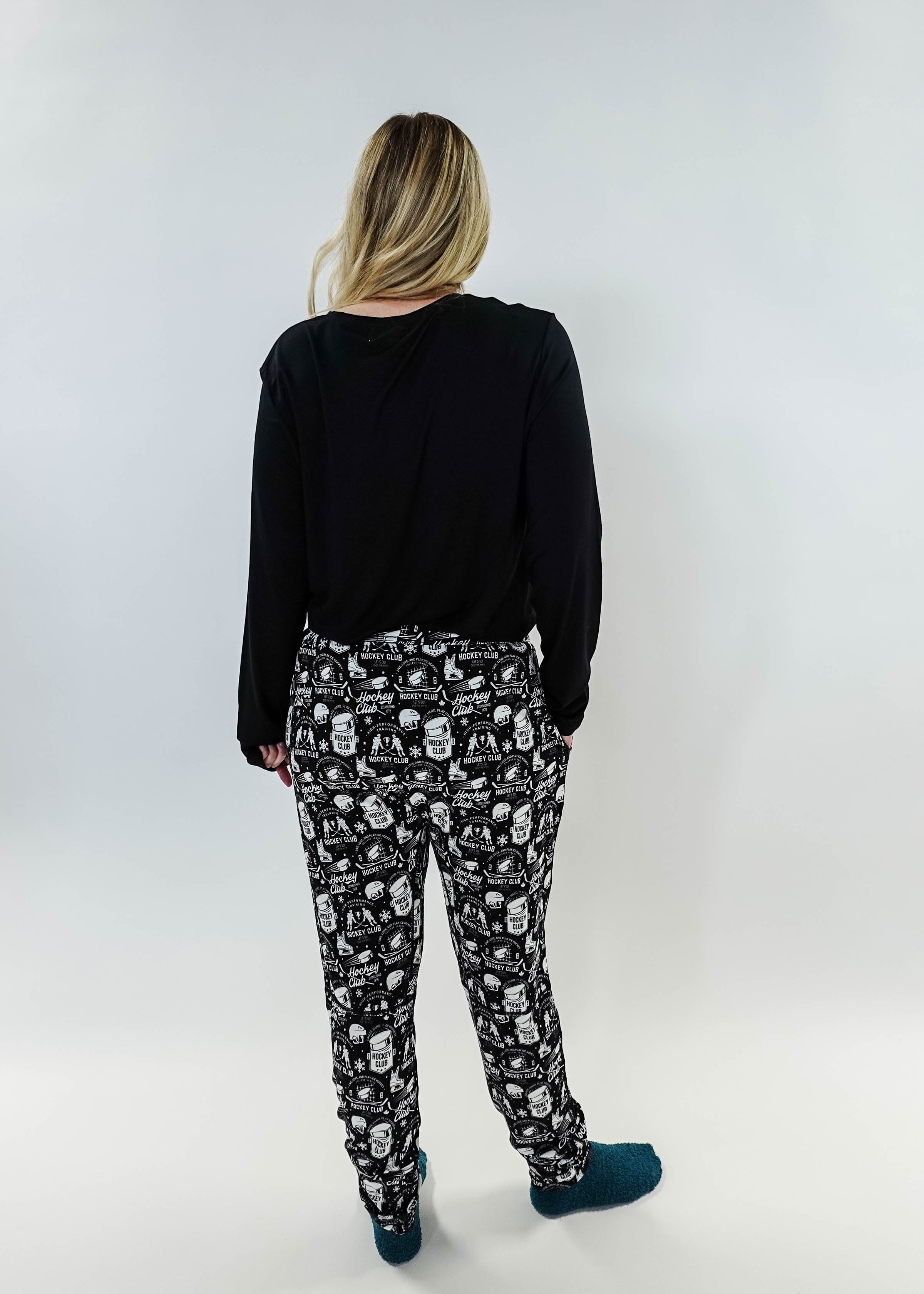 He Scores Hockey Print Unisex Bamboo Jogger worn by a person showing the back view with black top and patterned joggers.