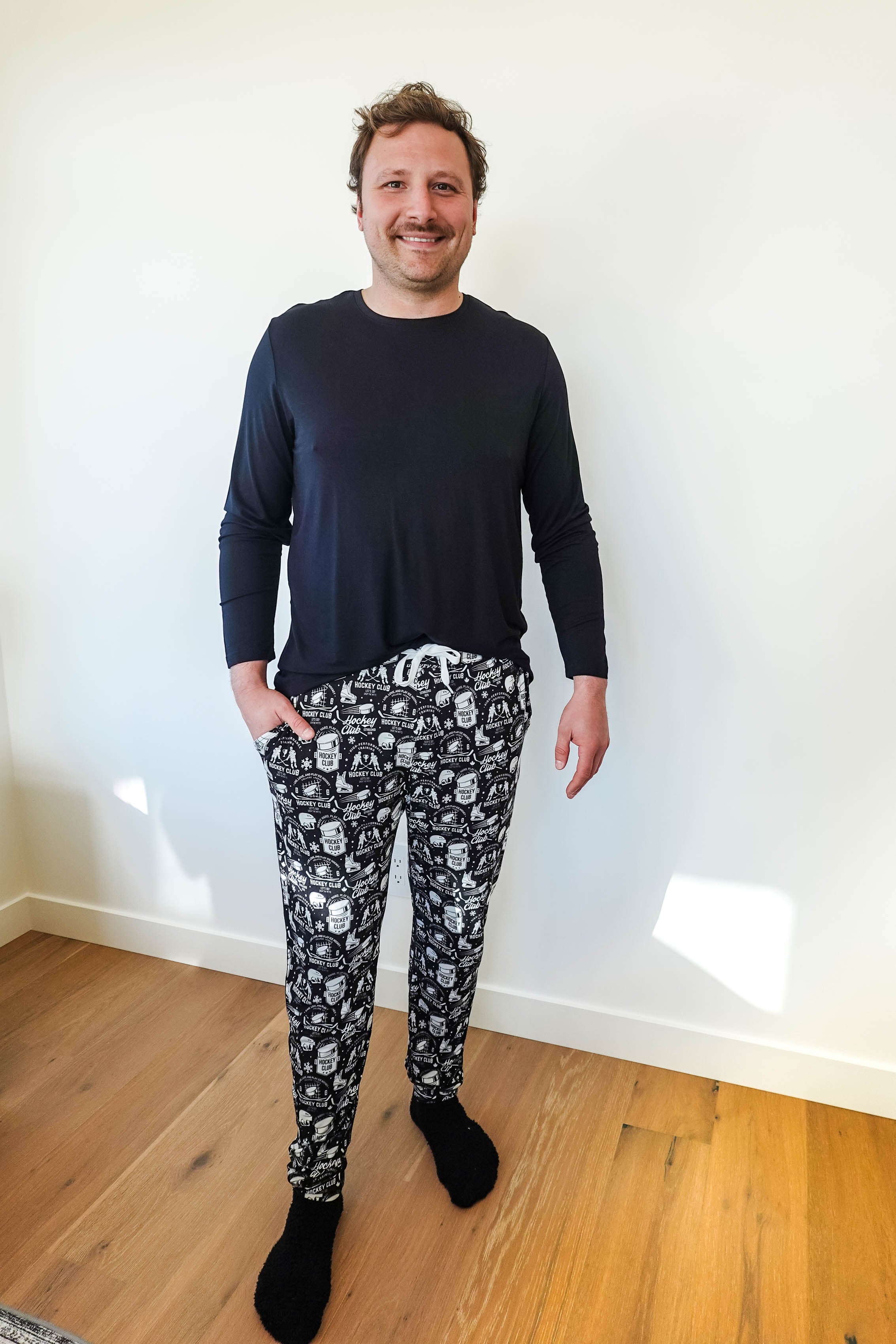 He Scores Hockey Print Unisex Bamboo Jogger showcased on a man wearing a black long sleeve shirt.