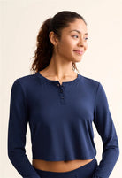 Model wearing the Ink Blue TENCEL™ Modal Cropped Henley Top. Highlighting the slight crop, functional buttons, and ribbed texture.