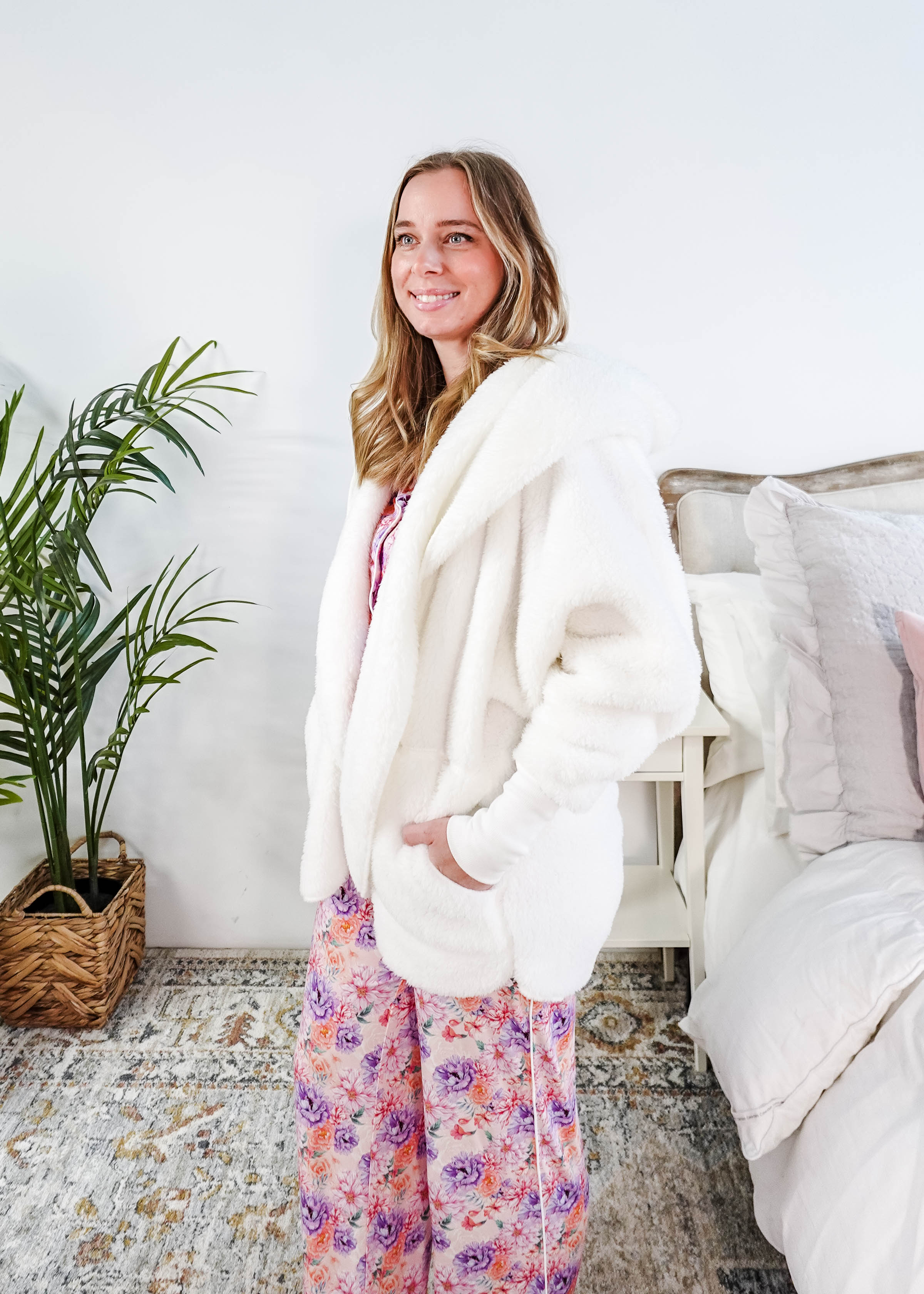 Essential Hooded Fluffy Cozy Cardigan with Pockets worn by a woman with floral pajamas in a cozy bedroom setting.