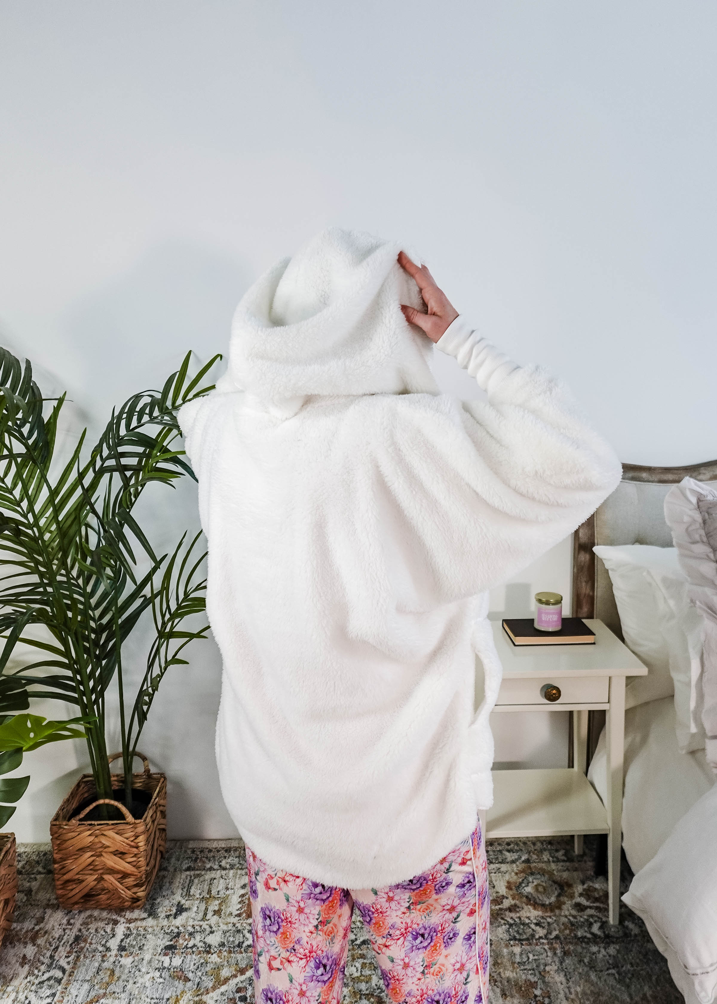 Essential Hooded Fluffy Cozy Cardigan with Pockets worn by a woman with floral pajamas in a cozy bedroom setting.