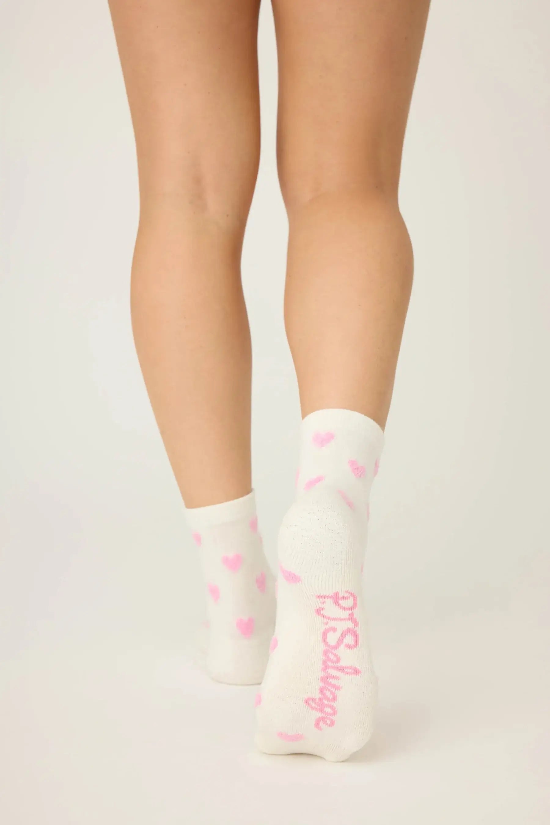 Pair of PJ Salvage "Love You A Latte" Fuzzy Crew Socks in ivory with an all-over pink heart print. Showing the mid-height crew cut and plush texture.