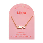 Zodiac Script Necklace in 14K Plated Gold featuring the astrological sign Libra on a pink card by Foxy Originals.