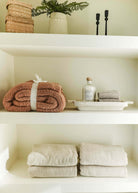 Mocha Brown Cozy Cabin Blanket shown on shelf in a luxury bathroom