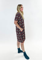 Merry Mugs V-Neck Bamboo Nightshirt featuring a whimsical holiday print, modeled by a woman standing with a cheerful expression.