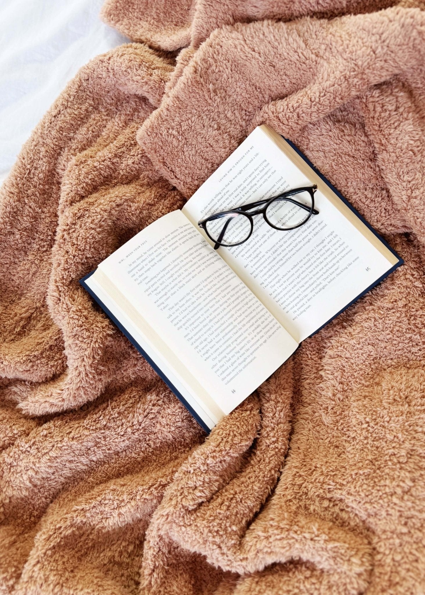 Mocha Brown Cozy Cabin Blanket laid across a bed with a book