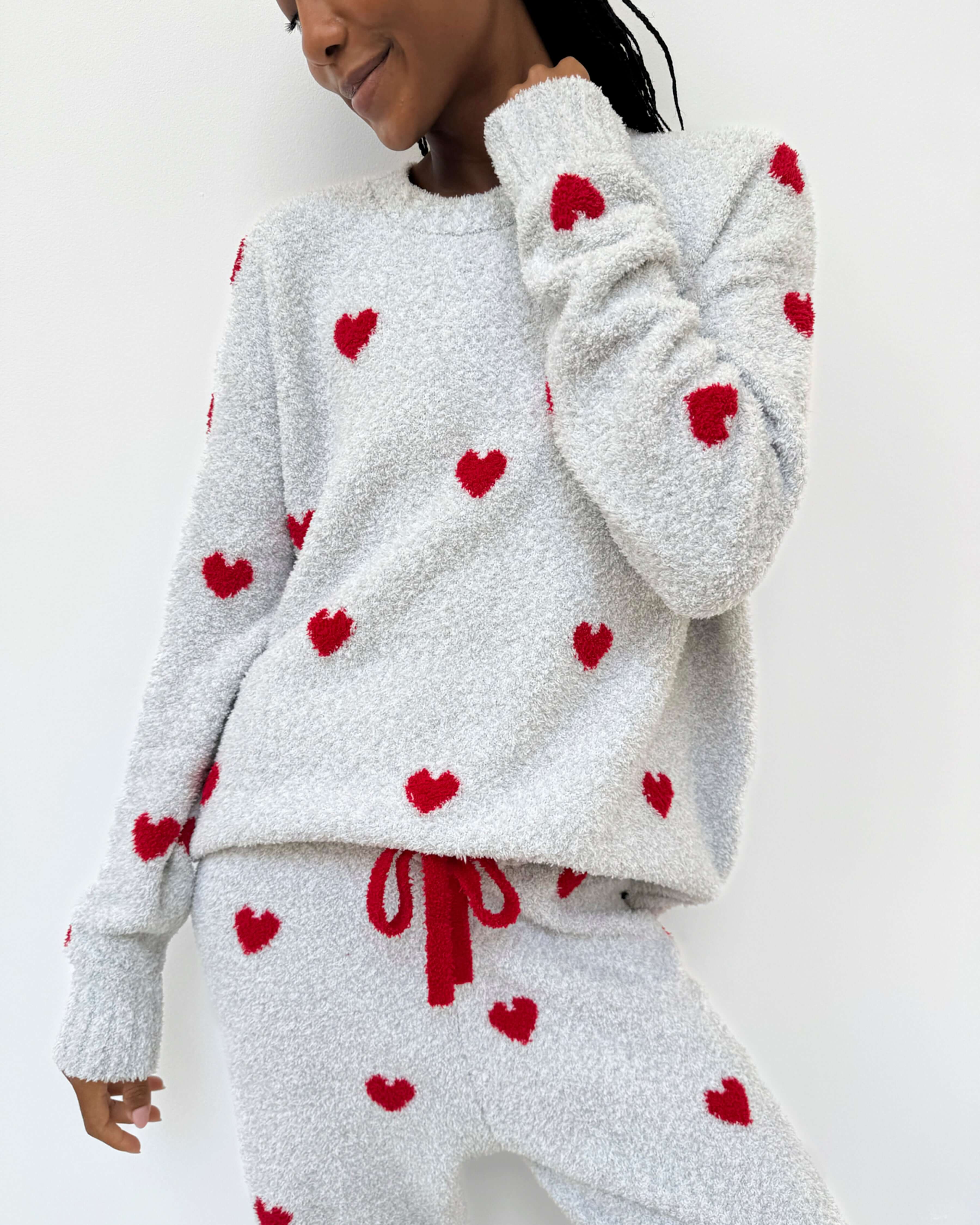 Woman wearing Cloud-Soft Fuzzy Sweater Pajama Set Splendid with heart patterns, showcasing cozy loungewear style. close up of heart print on grey background and fuzzy cozy fabric