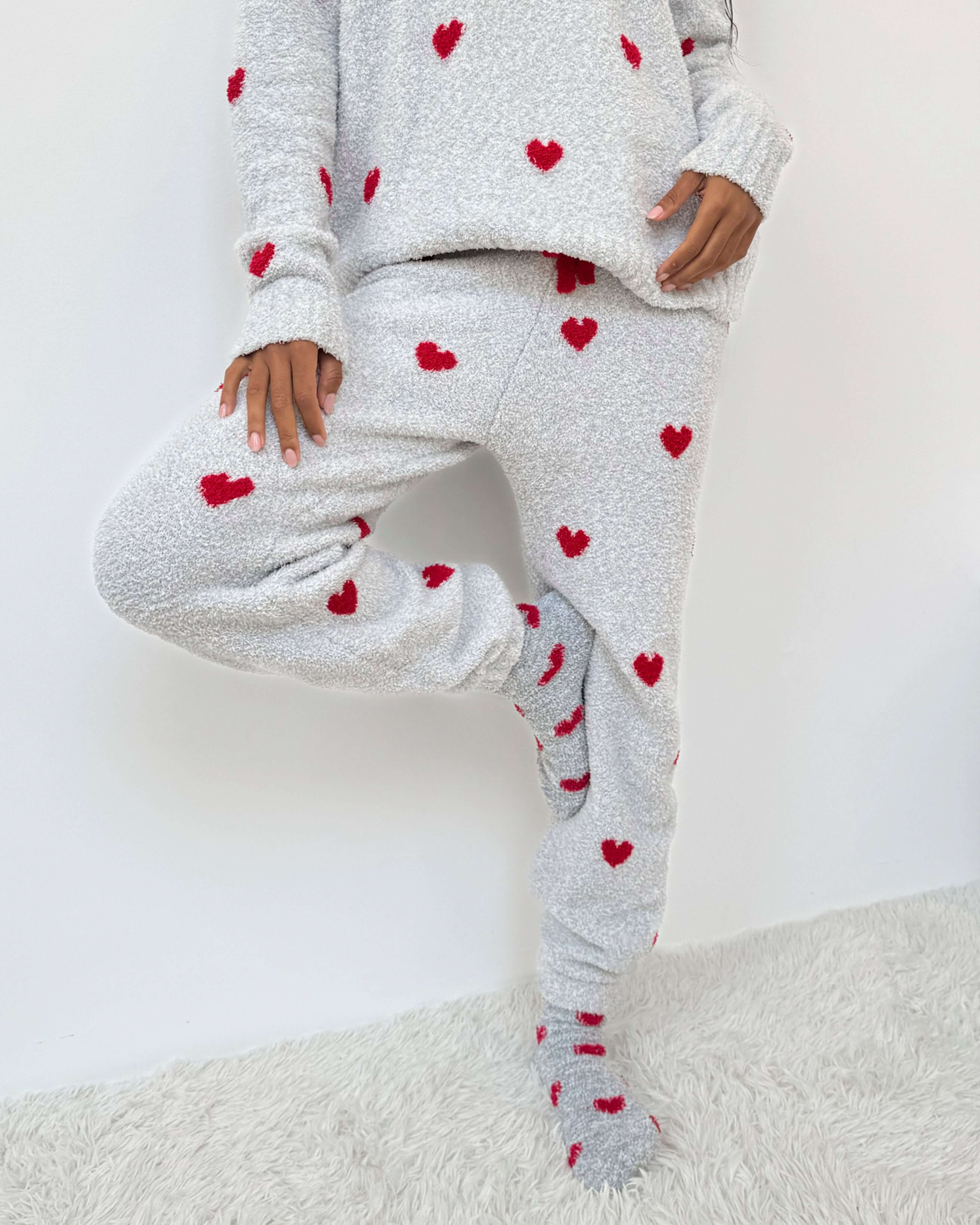 Woman wearing Cloud-Soft Fuzzy Sweater Pajama Set Splendid with heart patterns, showcasing cozy loungewear style. Showing leg cuff and fit 