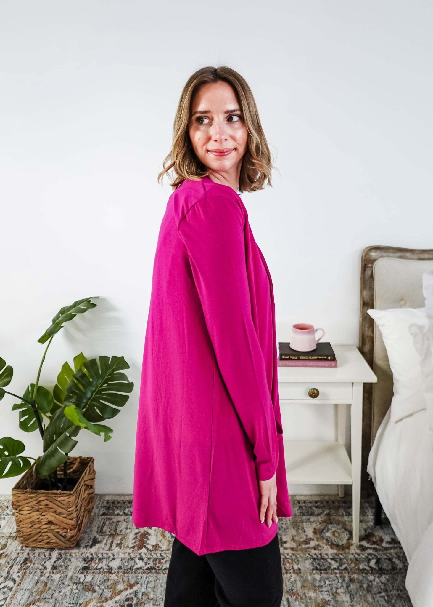 Woman in a bright pink cardigan  standing in a bedroom. Scarlett Ellie Summer Open Lightweight Cardigan | Cloud Nine Pajamas