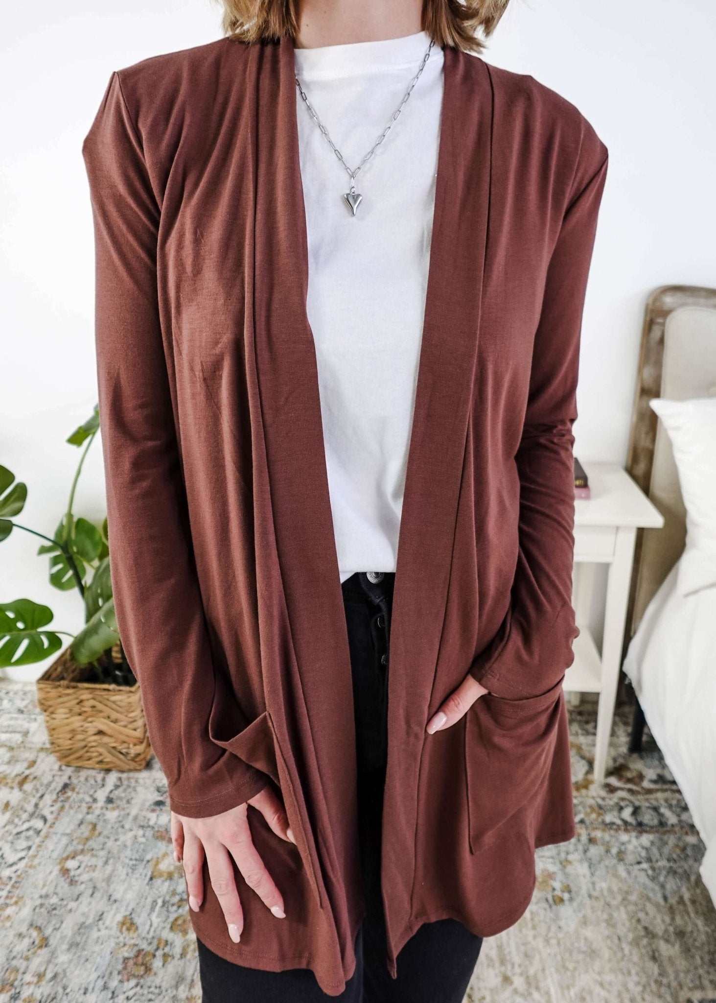Person wearing a brown cardigan over a white shirt in a casual setting. Scarlett Ellie Summer Open Lightweight Cardigan | Cloud Nine Pajamas