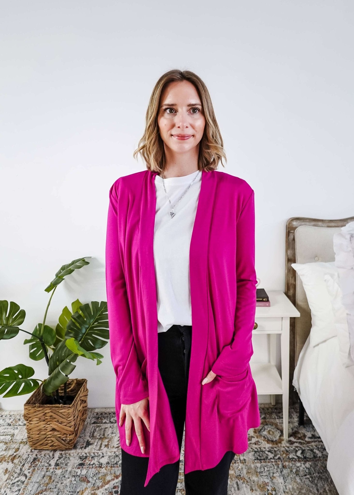 Woman wearing a bright pink cardigan in a bedroom setting Scarlett Ellie Summer Open Lightweight Cardigan | Cloud Nine Pajamas