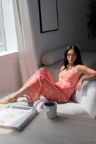 Woman lounging in Cami & High Waist Capri PJ Set, enjoying comfort in a bright, stylish sleepwear ensemble.