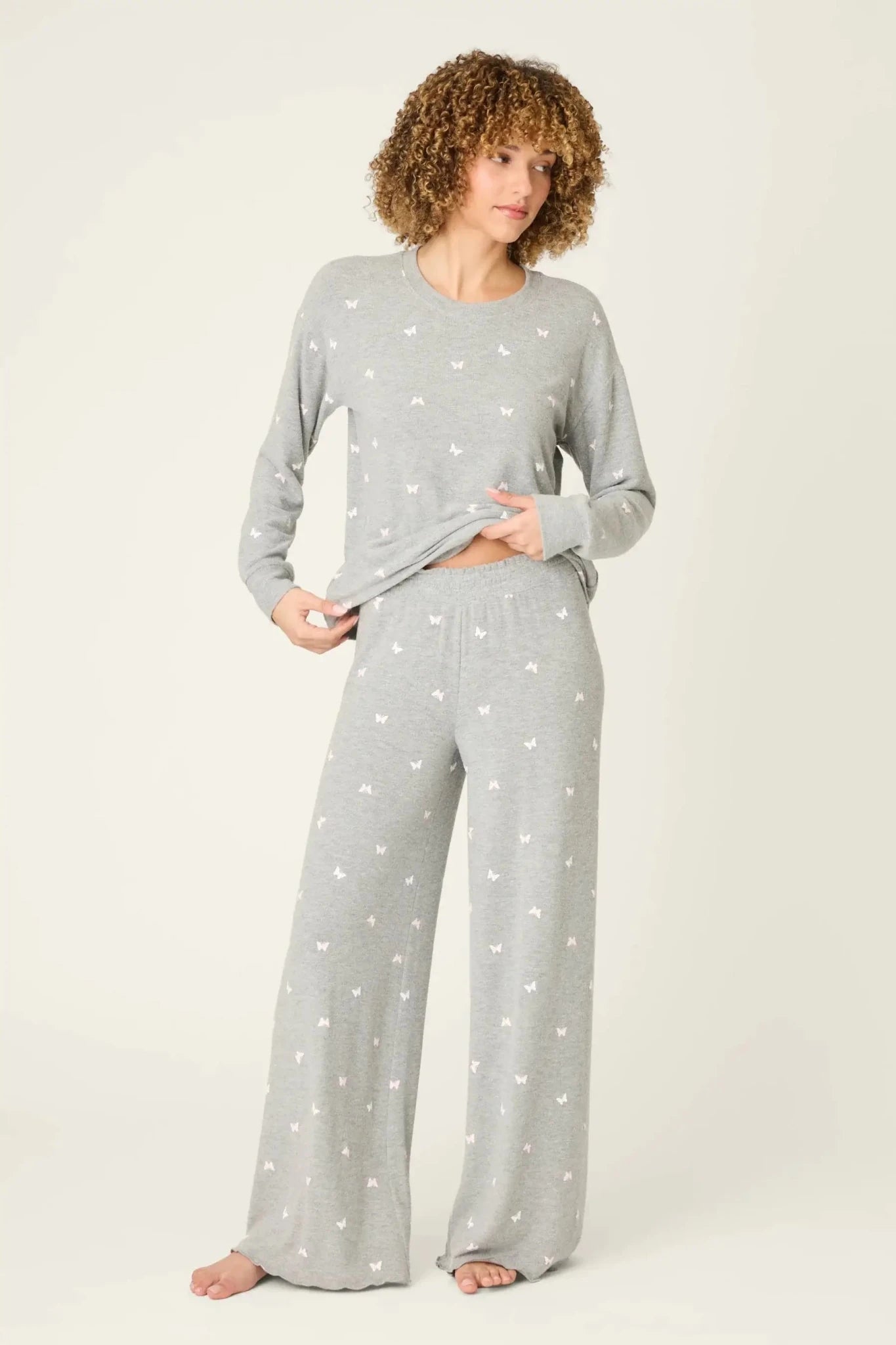 Model wearing PJ Salvage Peachy Butterfly Kisses Lounge Set featuring a heathered grey top and wide-leg pants.