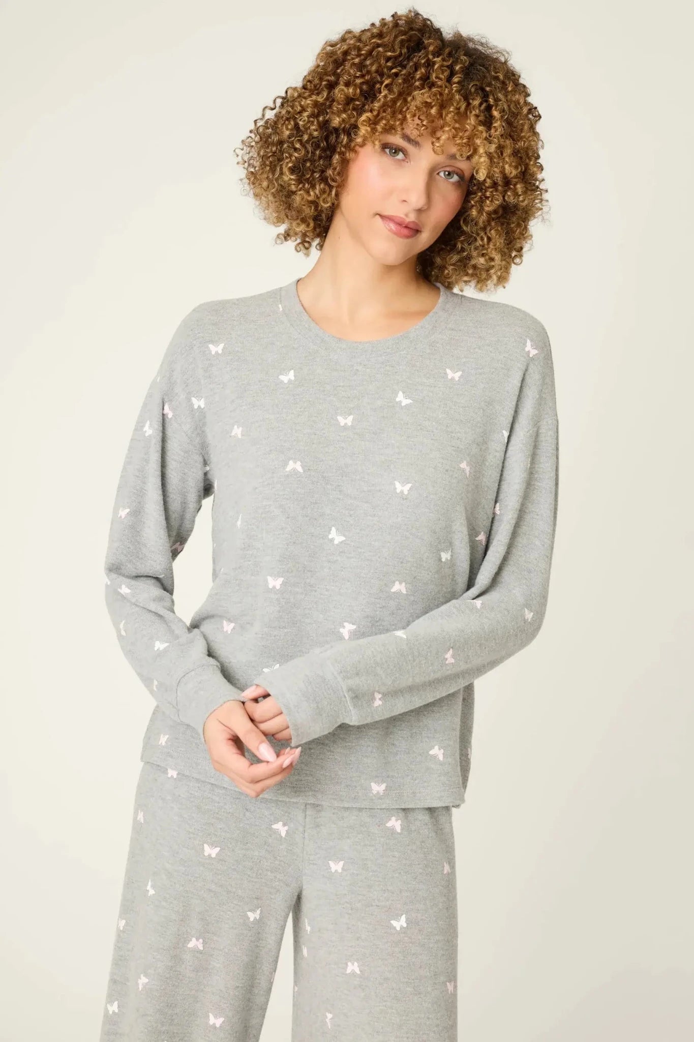 Model wearing PJ Salvage Peachy Butterfly Kisses Lounge Set featuring a butterfly print on a grey fabric.