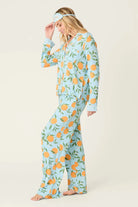 Model wearing PJ Salvage Citrus Dreams 3-Piece PJ Set featuring orange design with matching eye mask. Side View