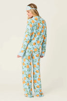 Model wearing PJ Salvage Citrus Dreams 3-Piece PJ Set featuring orange design with matching eye mask. Back View