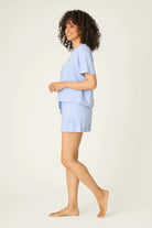 PJ SALVAGE Graphic Print Softee Tee & Short Lounge Set in "Nap Time is my Happy Hour" graphic tee shirt in light blue. Model stands against a light background in a side profile shot