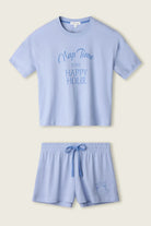 PJ SALVAGE Graphic Print Softee Tee & Short Lounge Set in "Nap Time is my Happy Hour" graphic tee shirt in light blue. Product lay flat on a light background shot
