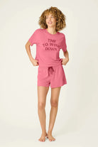 PJ SALVAGE Graphic Print Softee Tee & Short Lounge Set in "Time to Wine Down" rose pink. Model stands against a light background in a full length shot