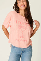 Model wearing PJ Salvage Paloma Mama "Tequila Por Favor" Graphic Tee in light pink with a cocktail graphic.