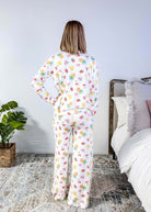 PJ SALVAGE — Viva la Vida Fruit Fiesta Long Sleeve & Pant Set worn on model in a bedroom setting, showing full length of the fruit print pj set from the back profile