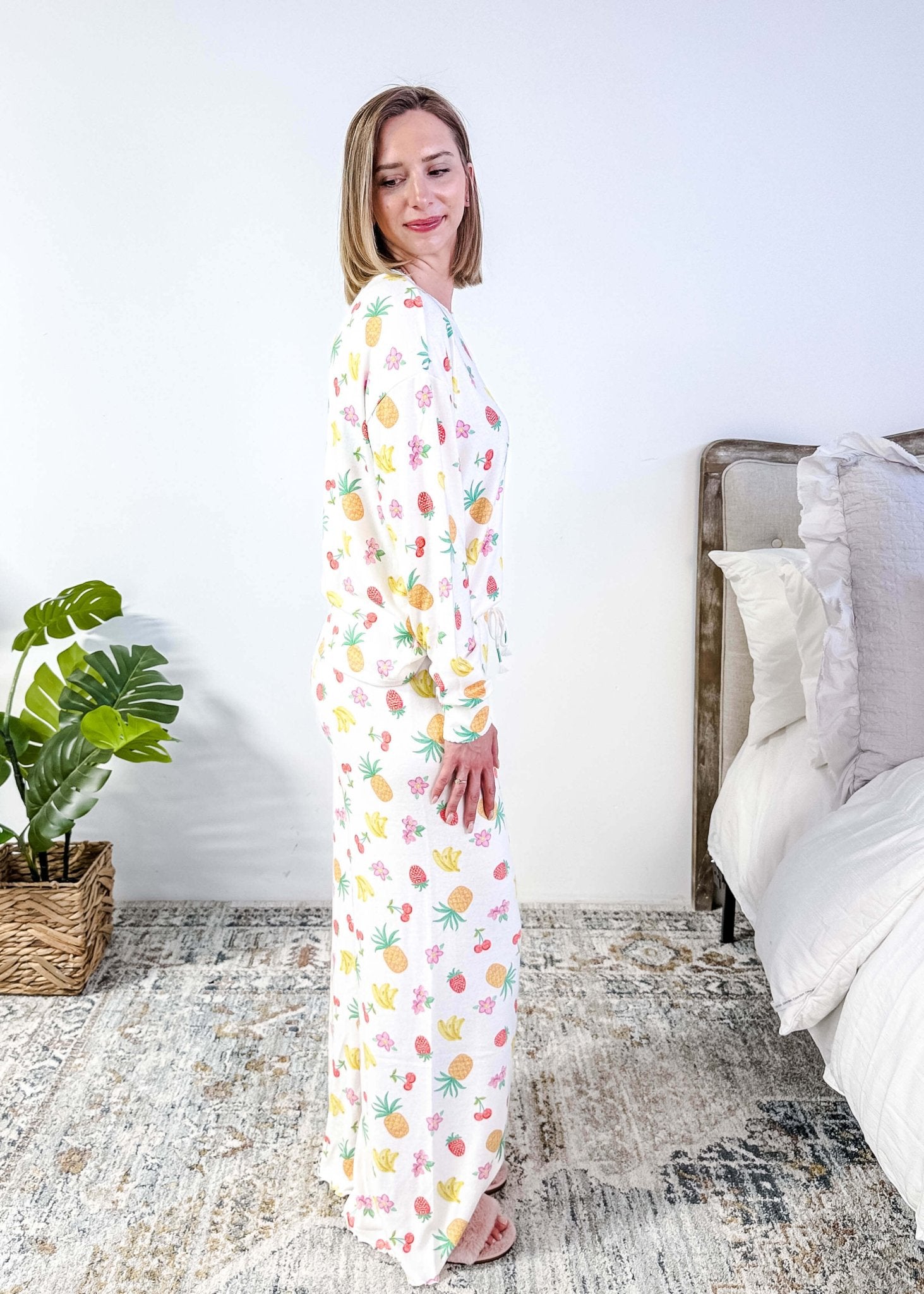 PJ SALVAGE — Viva la Vida Fruit Fiesta Long Sleeve & Pant Set worn on model in a bedroom setting, showing full length of the fruit print pj set from a side profile