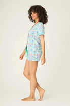 Model wearing PJ Salvage Whimsy Button Up & Short Short Set in a colorful print on a light background.