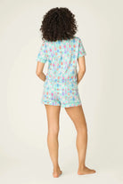 Model wearing PJ Salvage Whimsy Button Up & Short Short Set in colorful print from the back, showcasing the comfy style.