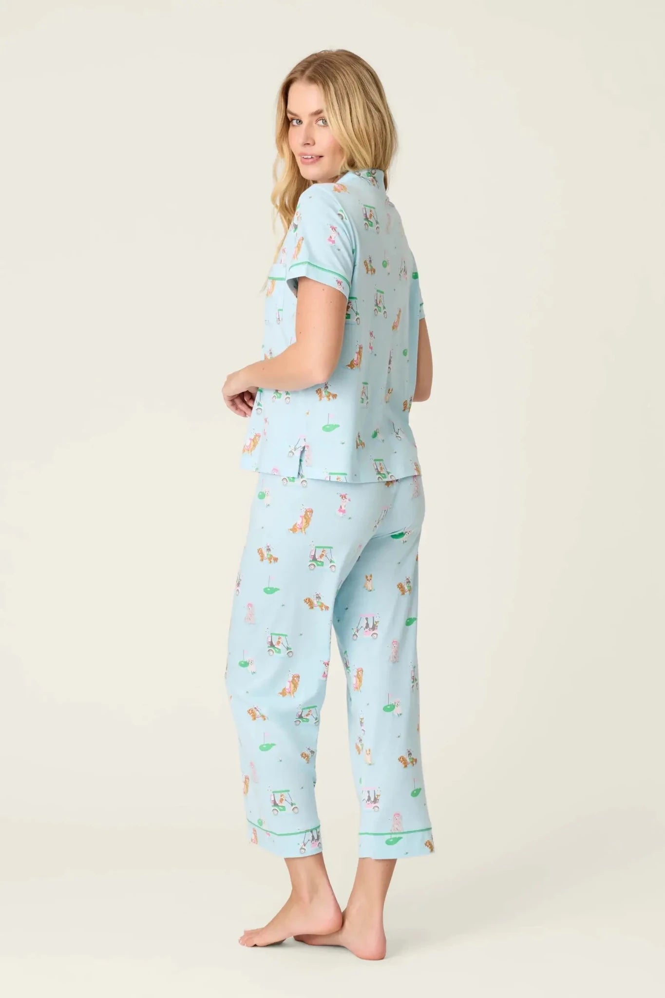 PJ SALVAGE Whimsy Cropped PJ Set in Light Blue Putter Pup print showing dogs golfing. Model stands wearing the set against a light background in a view of the back