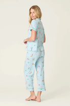 PJ SALVAGE Whimsy Cropped PJ Set in Light Blue Putter Pup print showing dogs golfing. Model stands wearing the set against a light background in a view of the back