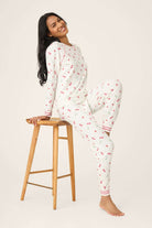 Model wearing Polka Dot Cherries Peachy Jersey Pajama Set PJ Salvage sitting on a stool, showcasing whimsical design.