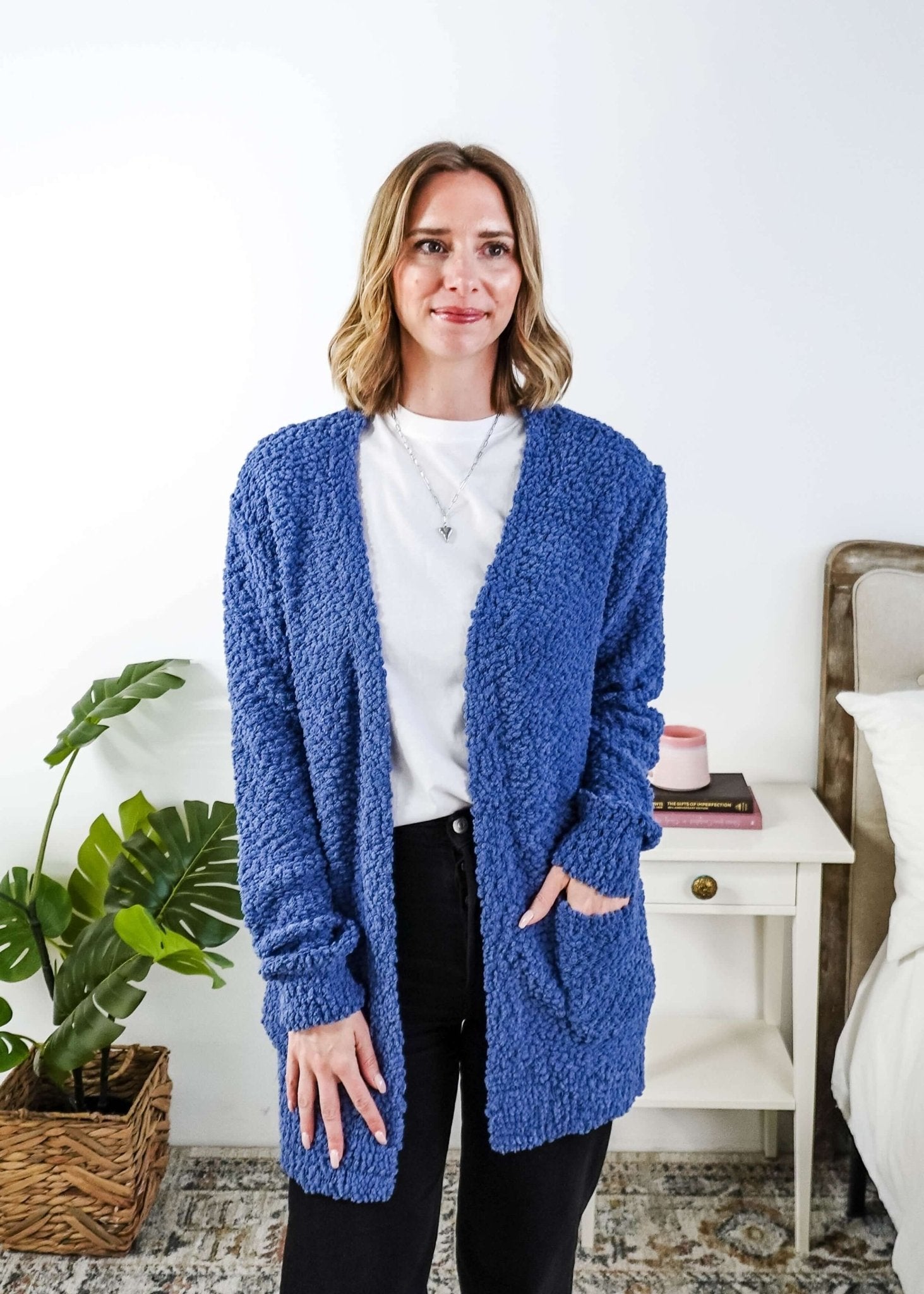 Woman wearing a blue cardigan with texture  in a bedroom setting, Popcorn Texture Open Summer Cardigan in a lake blue