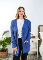 Woman wearing a blue cardigan with texture  in a bedroom setting, Popcorn Texture Open Summer Cardigan in a lake blue