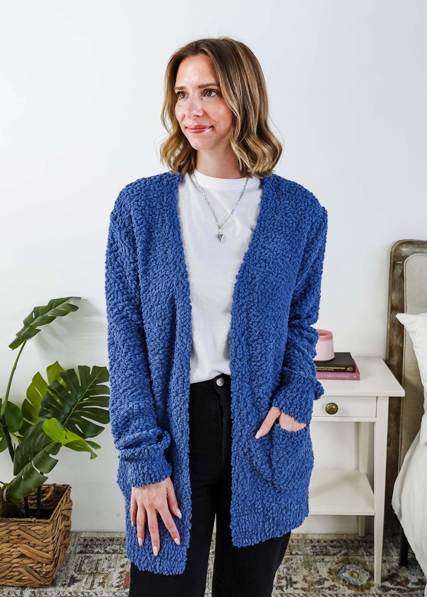 Popcorn Texture Open Summer Cardigan in blue, shown on model in a bedroom setting with hand in pocket