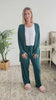 Women standing in a bedroom talking about the dark teal long bamboo cardigan. 