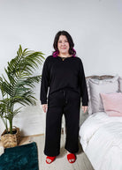 Black Long Sleeve Raw Edge Straight Pant Cloud Lounge Set worn by a model in a cozy home setting.