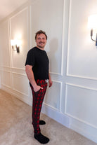 unisex joggers for men and women holiday red plaid print in soft bamboo fabric. Man wearing with classic black tee - view from side