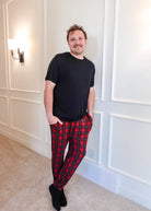 unisex joggers for men and women holiday red plaid print in soft bamboo fabric. Man wearing with black classic tee shirt