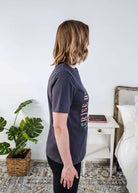 women wearing a dark grey graphic t-shirt with the saying rise with the sun death valley california
