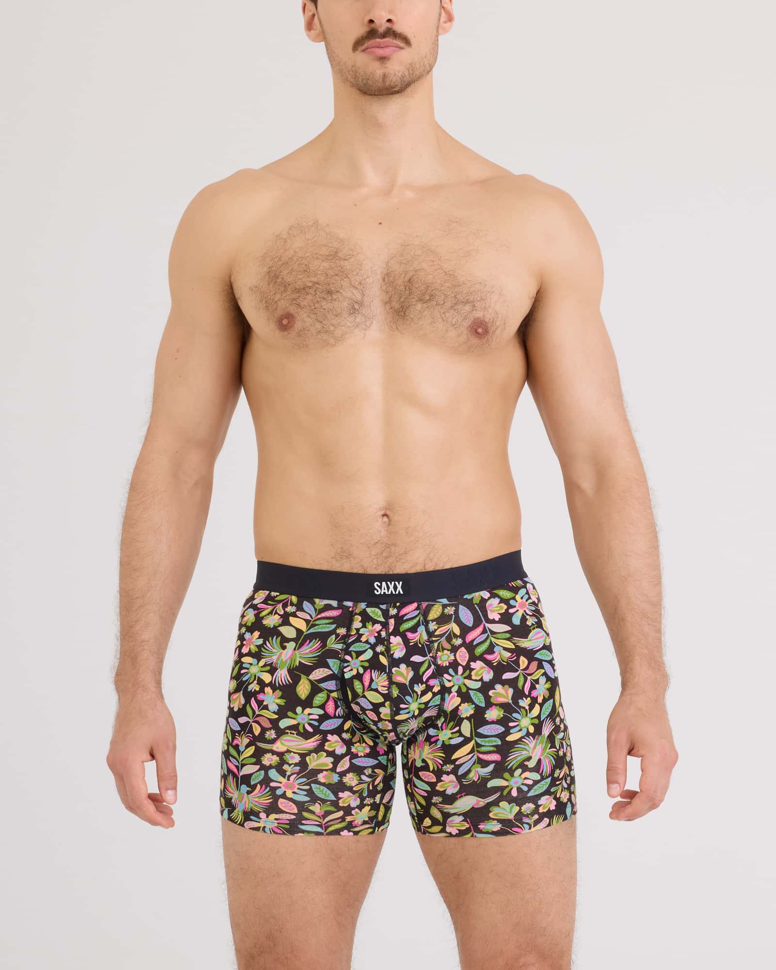 Vibe Xtra Soft Comfort Boxer Brief worn by a man, featuring a colorful floral print design from SAXX.
