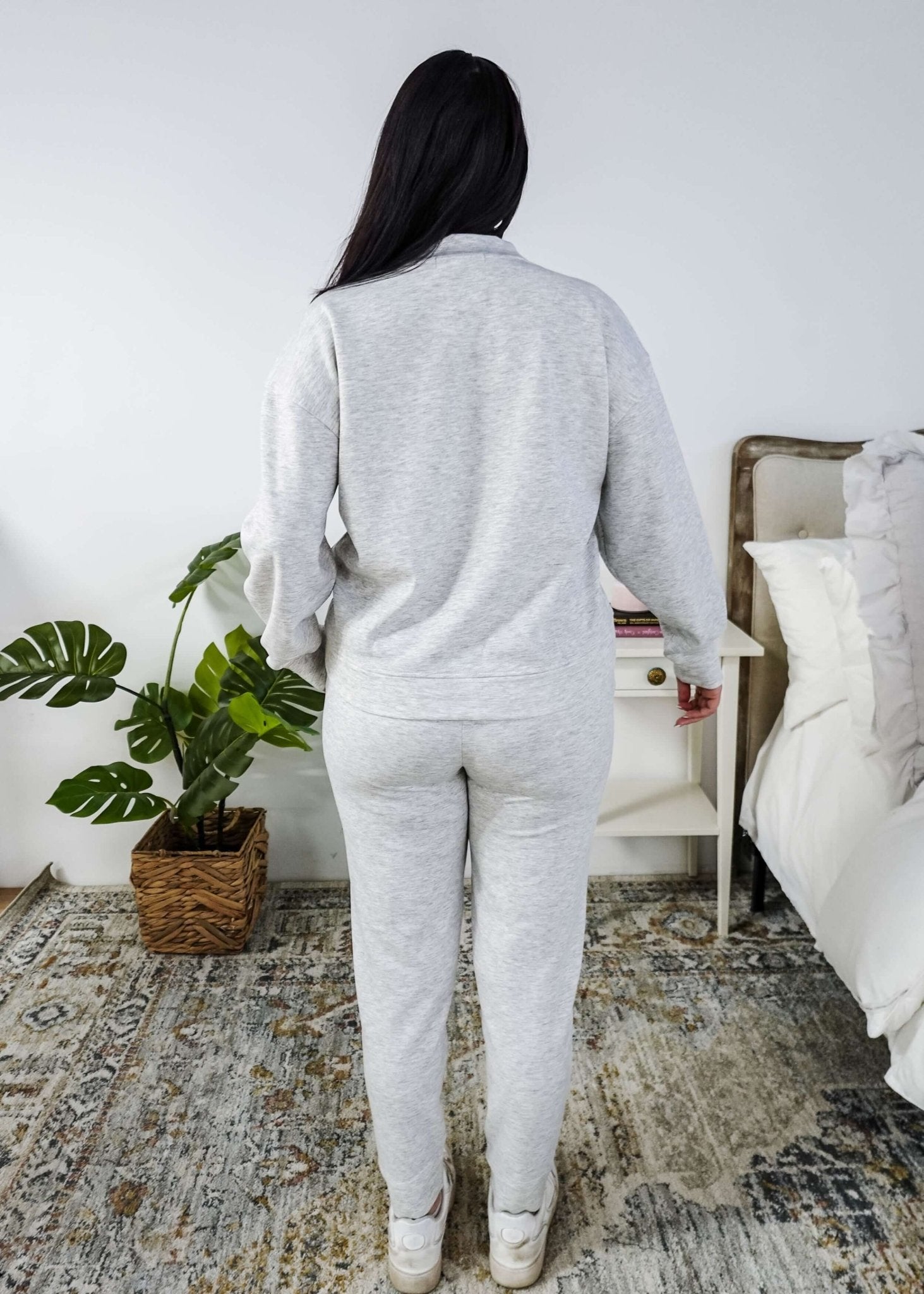 Person wearing a gray loungewear set in a bedroom setting.