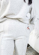 Person wearing a gray tracksuit with a elastic wiastband and blurred background