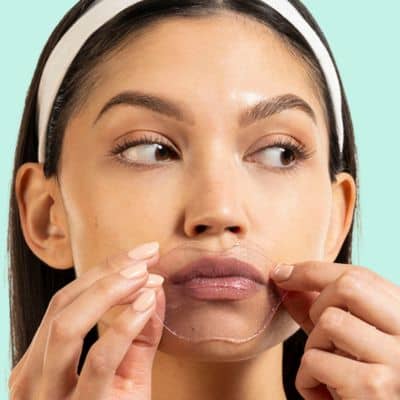 Woman applying Served Chilled Rosé Lips Gels hydrogel mask for moisturized and soft lips.