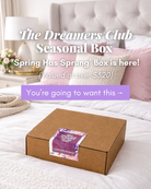 The Dreamer's Club Seasonal Box featuring the Spring Has Sprung edition on a stylish bed setting.