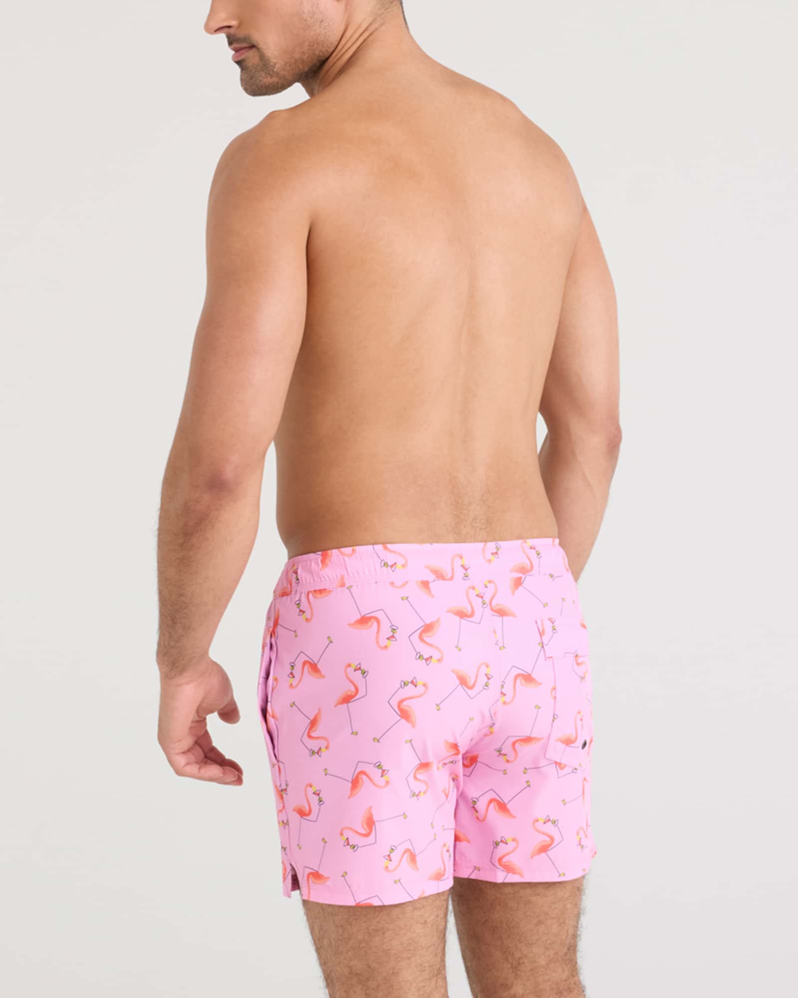 Man modeling the Oh Buoy 2N1 Volley Swim Short in pink flamingo pattern, showcasing a stylish summer look.